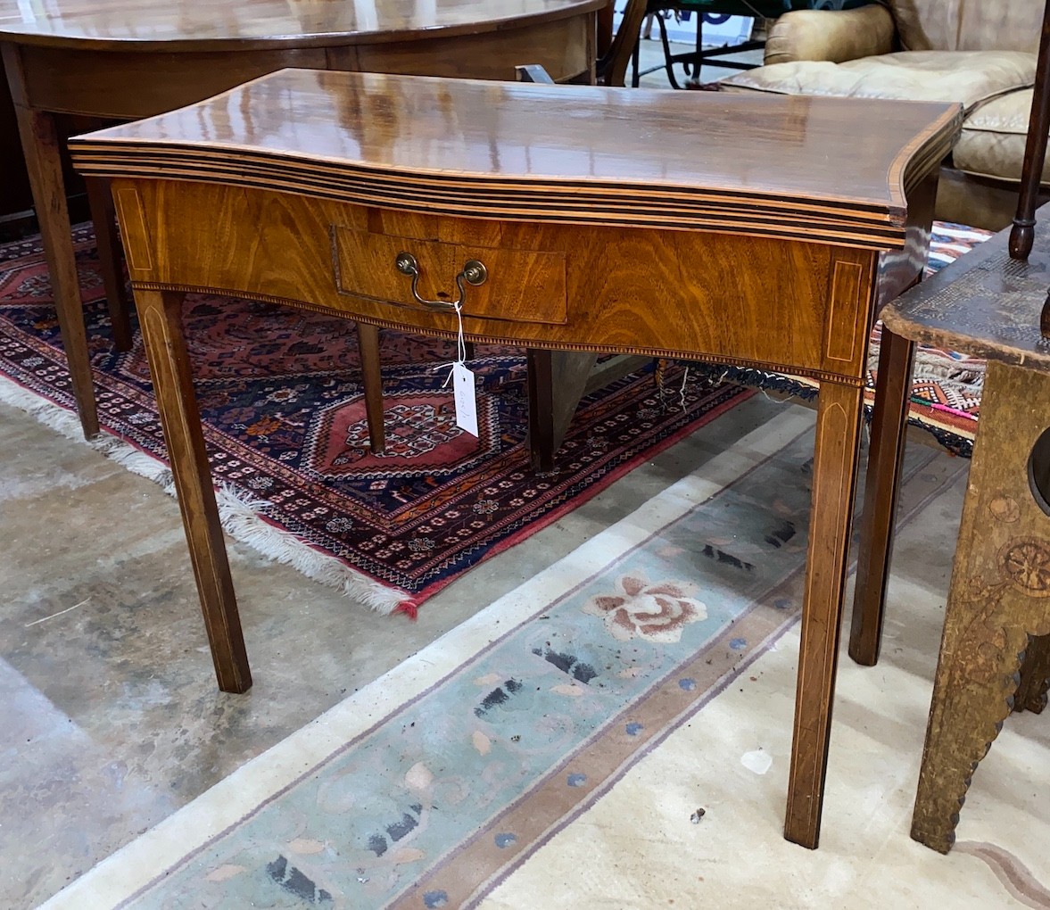 A George III satinwood banded serpentine mahogany folding tea table, width 84cm, depth 42cm, height 74cm